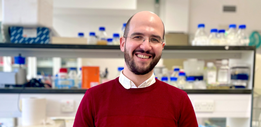 Alex Cagan, smiling, in laboratory