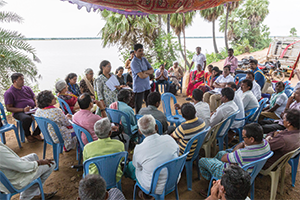 people sitting around one person speaking