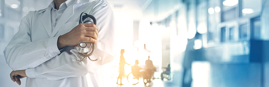 Doctor with arms crossed holding a stethoscope with people in the background