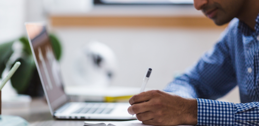 man writing and laptop