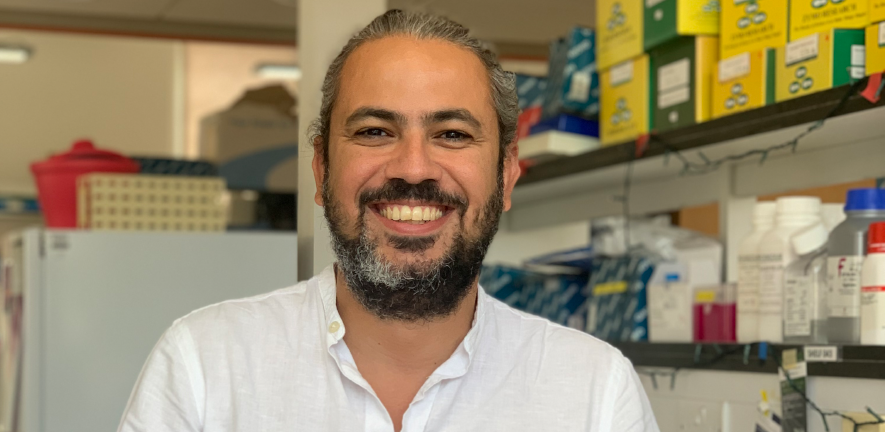 Felipe Karam Teixeira smiling in a white shirt in a laboratory