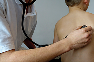 hand holding stethoscope on child's back