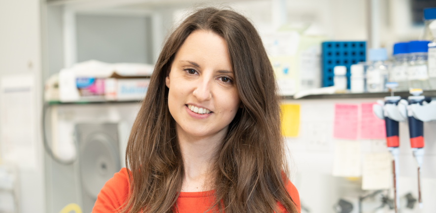 Profile photo of iva in a red top against a blurred background of a lab 