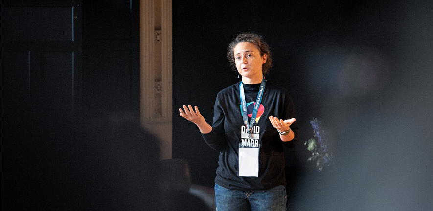 Elisa Galliano Photo of Elisa Galliano in a dark shirt presenting at a conference
