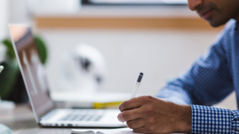 man writing and laptop