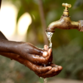 hands holding water coming out of tap