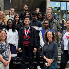 Group of students on the 2024 Postgraduate School of Life Sciences programme with the academic leads standing on a staircase outside the Museum of Zoology