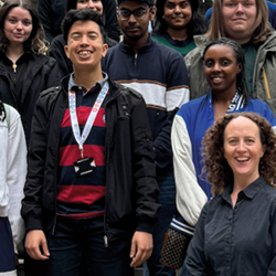 Group of students on the 2024 Postgraduate School of Life Sciences programme with the academic leads standing on a staircase outside the Museum of Zoology