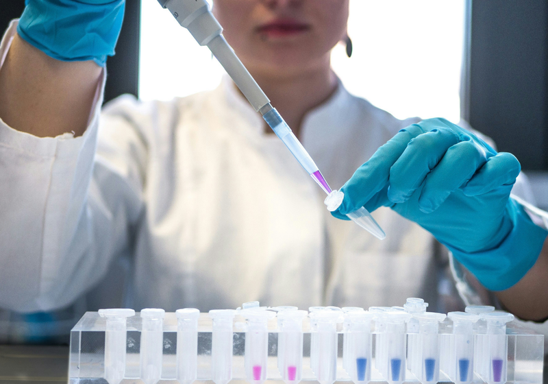 Woman scientist holding a pipette and tube