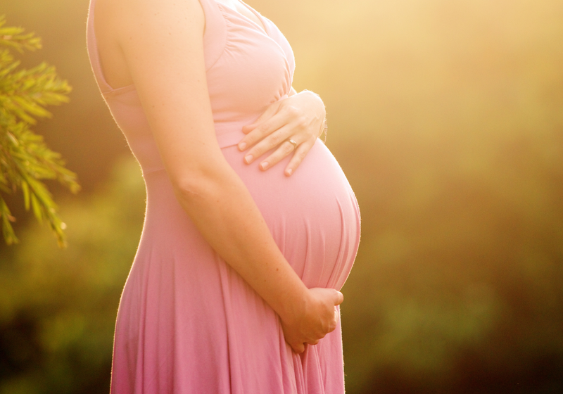 Pregnant woman with sun behind