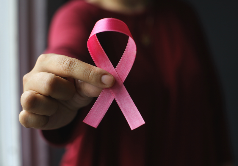 woman holding pink ribbon