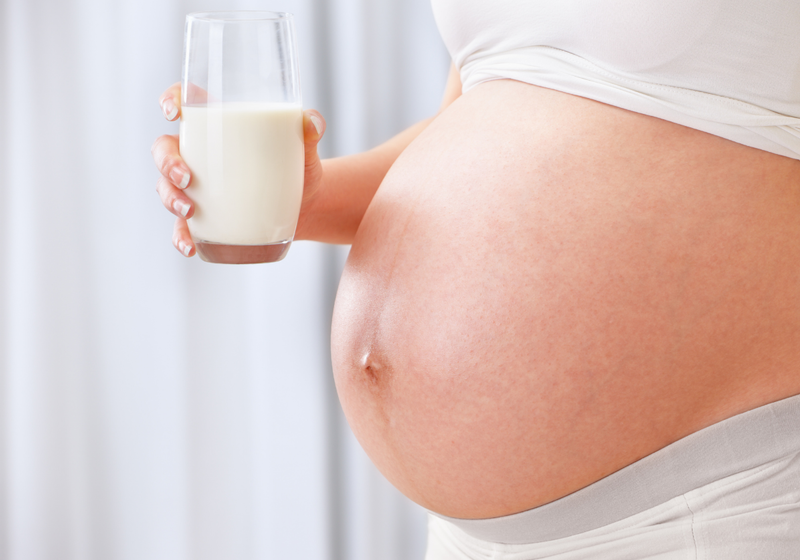 pregnant woman holding glass of milk