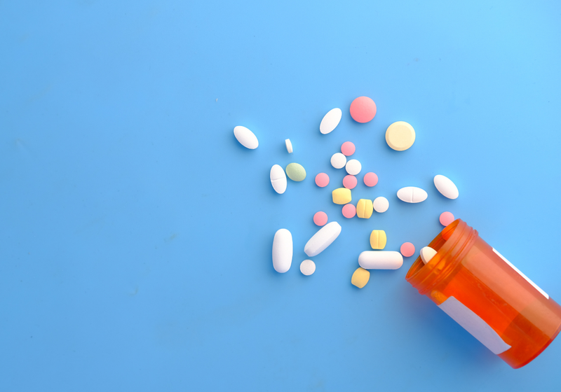 close up of colourful medication tablets on a blue background