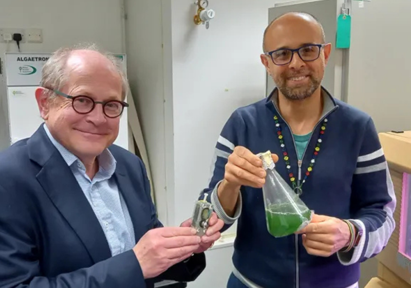Chris Howe and Paolo Bombelli holding algae device and a flask of algae