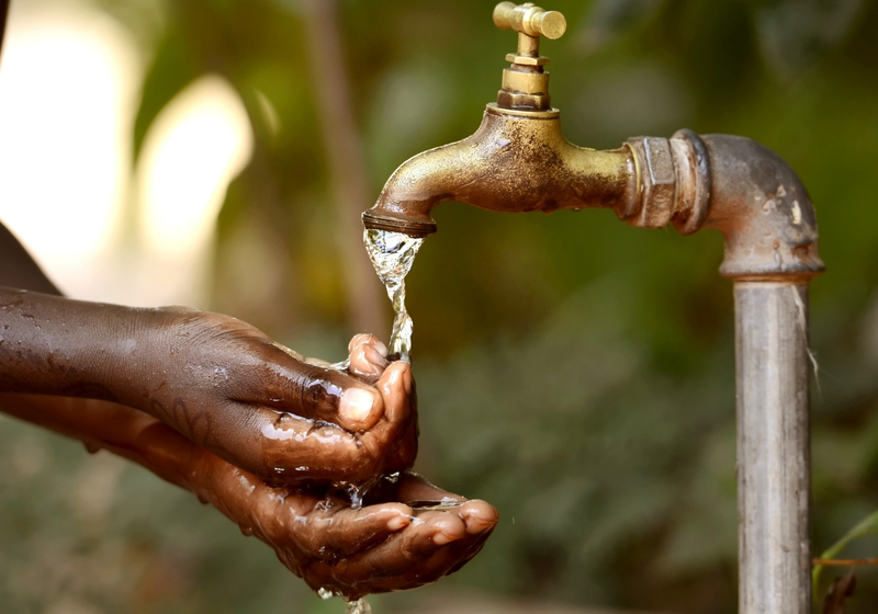 Hands holding water from a tap