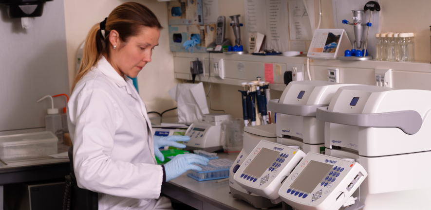 DNA sequencing facility person working with lab equipment