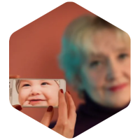 baby in phone screen with blurred woman in the background